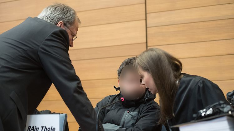 Der angeklagte Fahrdienstleiter mit seinen beiden Anwälten im Gerichtssaal. 