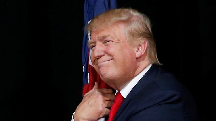 Donald Trump umarmt im Wahlkampf die US-Flagge.