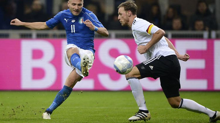 Ciro Immobile zirkelt den Ball um Benedikt Höwedes' Knie.