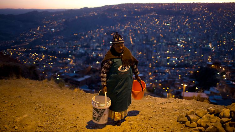 Eine ältere Frau in La Paz mit zwei Eimern für Wasser.