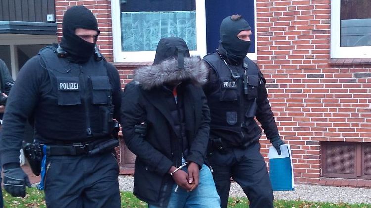 Einer der Hauptverdächtigen wird von der Polizei abgeführt.