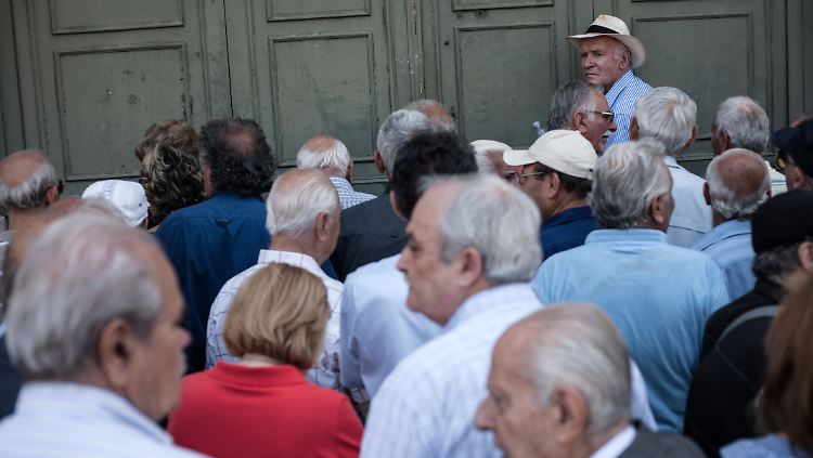 Pensionäre warten vor einer Bank auf Einlass, damit sie ihre Rente abholen können (Archivbild).