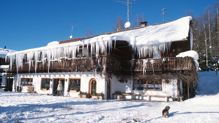 Winterromantik: schneebedecktes Bauernhaus im bayrischen Wald.