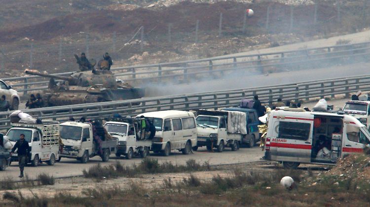 Ein syrischer Panzer bewacht einen Konvoi, der zurück in die umkämpften Rebellengebiete fährt.