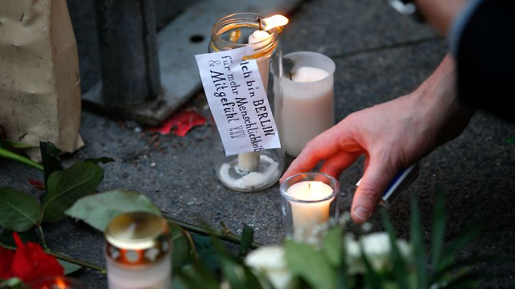 Am Breitscheidplatz legen Menschen Blumen nieder und zünden Kerzen an.