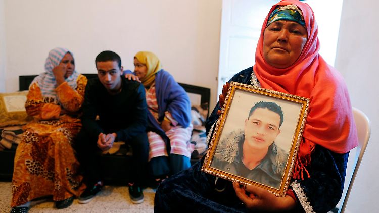 Die Mutter von Anis Amri (r.) und drei seiner Geschwister mit einem Bild des mutmaßlichen Attentäters von Berlin.