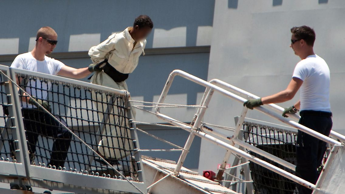 Das vom niederländischen Verteidigungsministerium veröffentlichte Foto zeigt, wie einer der somalischen Piraten eskortiert von niederländischen Mairnesoldaten in Djibouti von Bord gebracht wird.