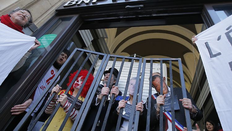 McDonalds, Bank-Angestellte, Jean-Claude-Juncker und der französische Politiker Balkany hinter Gittern: Protestaktion von Attac-Aktivisten.