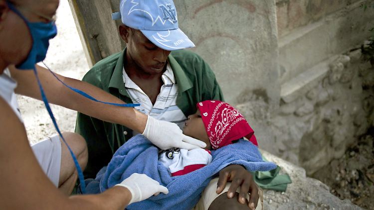 Ein Arzt prüft den Puls eines cholerainfizierten Kindes in Haiti.