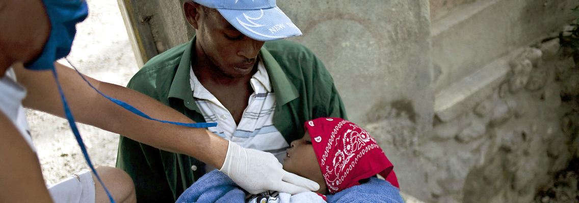 Ein Arzt prüft den Puls eines cholerainfizierten Kindes in Haiti.