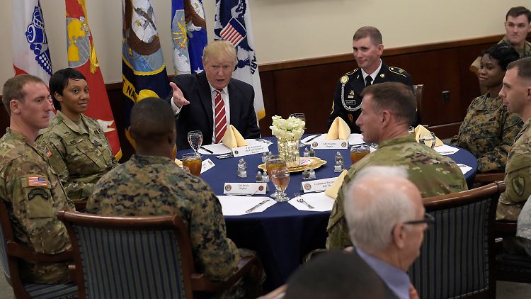 US-Präsident Donald Trump (M) beim Mittagessen mit Soldaten am 06.02.2017 auf der MacDill Air Force Base in Tampa (Florida). Trump besucht erstmals das Zentralkommando und das Spezialeinsatzkommando. Foto: Susan Walsh/AP/dpa +++(c) dpa - Bildfunk+++