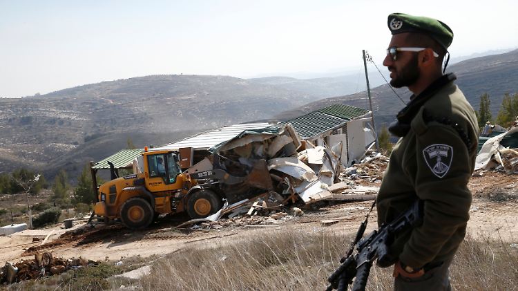 Ein israelischer Polizist beobachtet, wie ein Haus auf annektiertem israelischen Gebiet bei Amona zerstört wird.