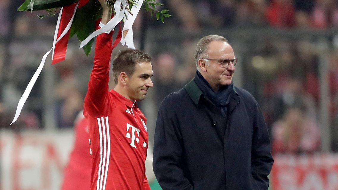 Bayern's Philipp Lahm waves on the field with flowers besides Bayern CEO Karlheinz Rummenigge prior to the German Soccer Cup match between FC Bayern Munich and VfL Wolfsburg at the Allianz Arena stadium in Munich, Germany, Tuesday, Feb. 7, 2017. (AP Photo/Matthias Schrader)