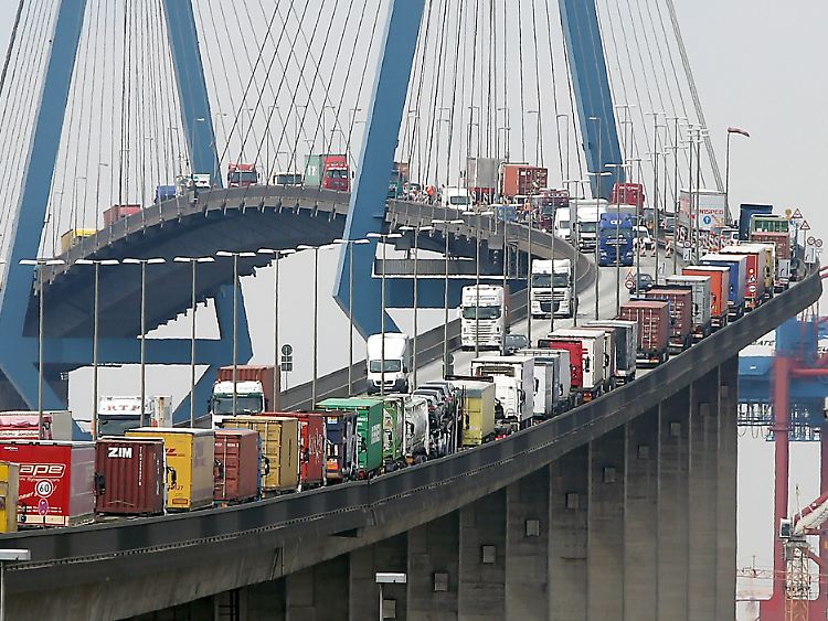 Mit Containern beladene Lastwagen stauen sich auf der Köhlbrandbrücke im Hafen von Hamburg.