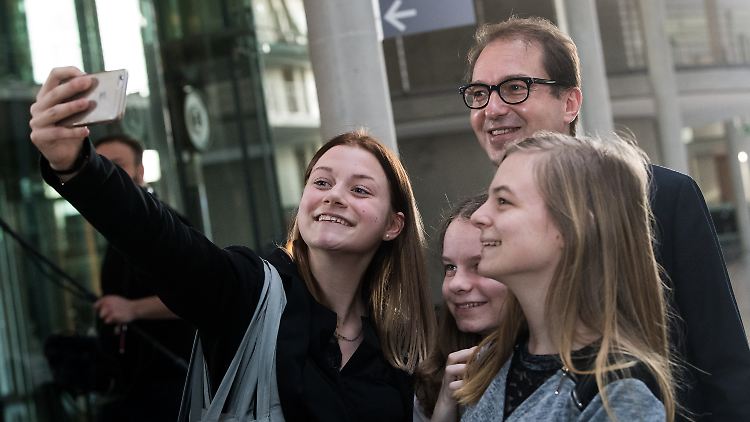 Volksnah: Verkehrsminister Dobrindt lässt junge Bundestagsbesucherinnen vor der Ausschusssitzung Selfies mit sich machen.