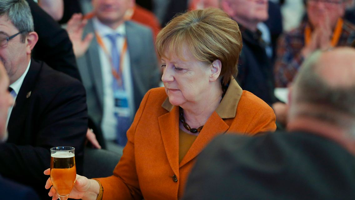 Woran Merkel wohl gerade denkt? An 2012? Als ihr ein Kellner fünf Gläser in den Nacken kippte?