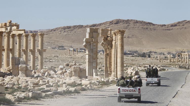 Syrische Soldaten fahren durch die Ruinen der antiken Stätten von Palmyra.