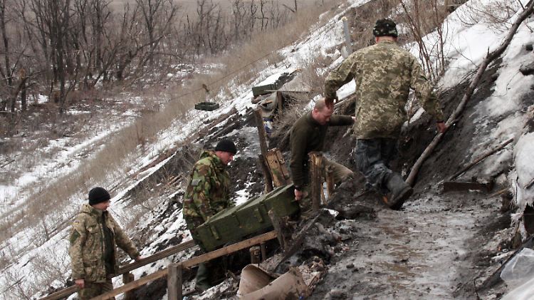 Ukrainische Soldaten schleppen eine Munitionskiste über eine vereiste Treppe zu ihrer Stellung im "Ameisenhügel" bei Donezk hinauf.