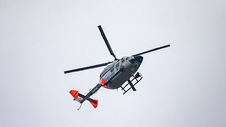 Ein Polizeihubschrauber kreist über einem Waldgebiet in unmittelbarer Nähe des Tatorts.