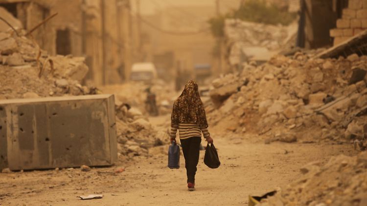 Zerstörte Häuser, wohin man blickt: eine Frau im syrischen Al Bab.