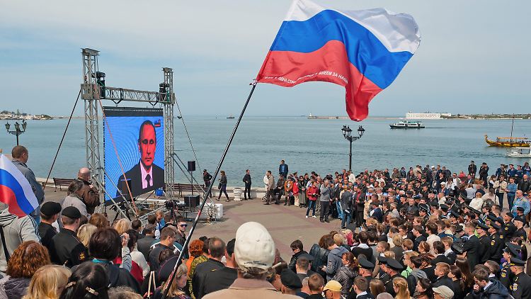 Menschen in Sewastopol auf der Krim sehen sich eine Fernseh-Ansprache des russischen Präsidenten an (Archivbild von 2014).