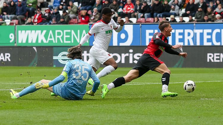 Gleich fällt er: Augsburgs Marwin Hitz bringt den Freiburger Mike Frantz per Grätsche zu Fall.