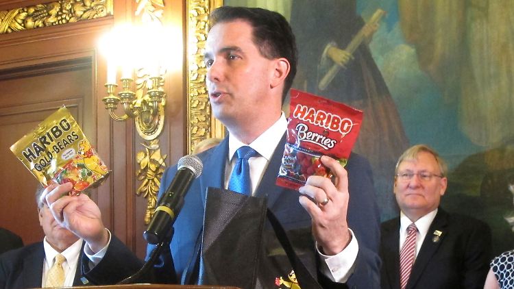 Mit zwei Haribo-Tüten in den Händen kündigt Gouverneur Scott Walker an, dass Haribo nun eine Fabrik in Wisconsin bauen werde.
