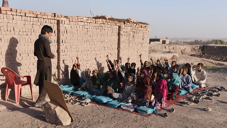 Diese aus Pakistan heimgekehrten Kinder werden unter freiem Himmel unterrichtet.