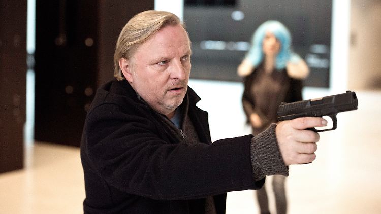 Kommissar Frank Thiel (Axel Prahl) zückt die Waffe bei einem Einsatz im LWL Museum für Kunst und Kultur; im Hintergrund steht Leila (Janina Fautz) mit ihrem schlumpfblauen Haar.