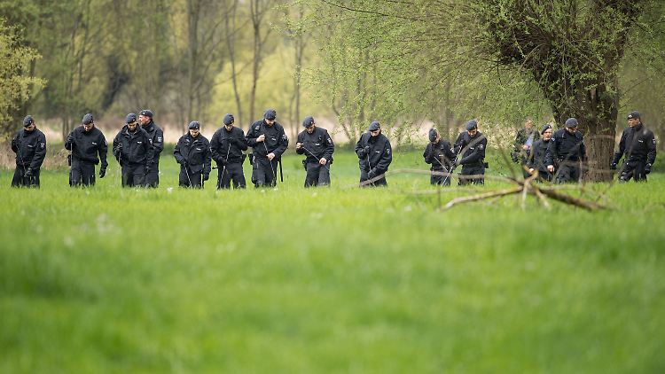 Brutaler Überfall: Schritt für Schritt suchen Polizisten einer Einsatzhundertschaft in den Siegauen bei Bonn nach Spuren.