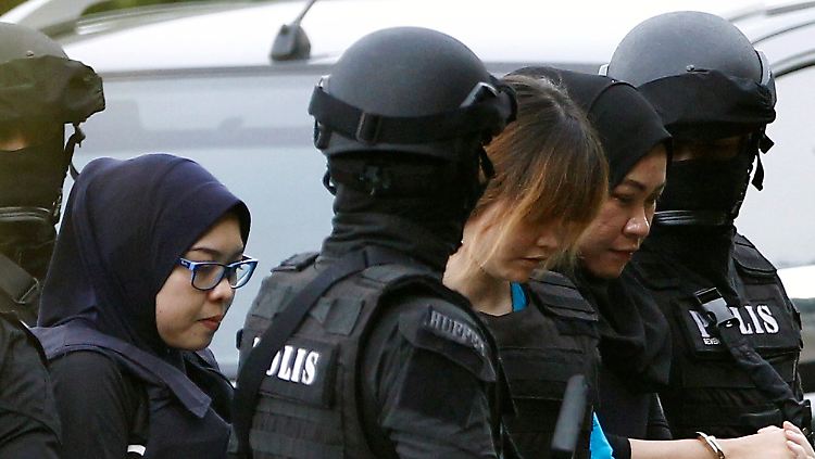 Unter strengsten Sicherheitsvorkehrungen wird eine der Tatverdächtigen ins Gericht geführt.