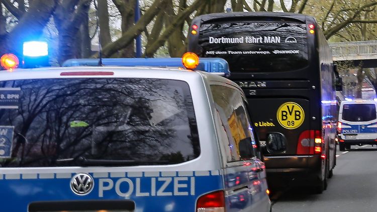 Der Mannschaftsbus des BVB wird von Polizeiwagen begleitet.