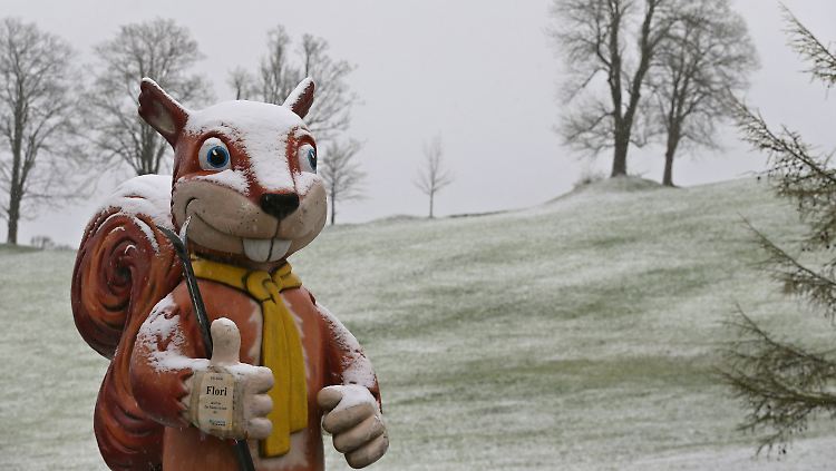 Auch wenn der Schnee wohl nicht mehr zum Skifahren reicht, freut sich das überdimensionale Eichhörnchen vor einer Skischule.