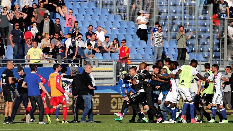 Szenen, die im Fußball nichts zu suchen haben: Die Spieler von Olympique Lyon müssen vor korsischen Fans beschützt werden. 