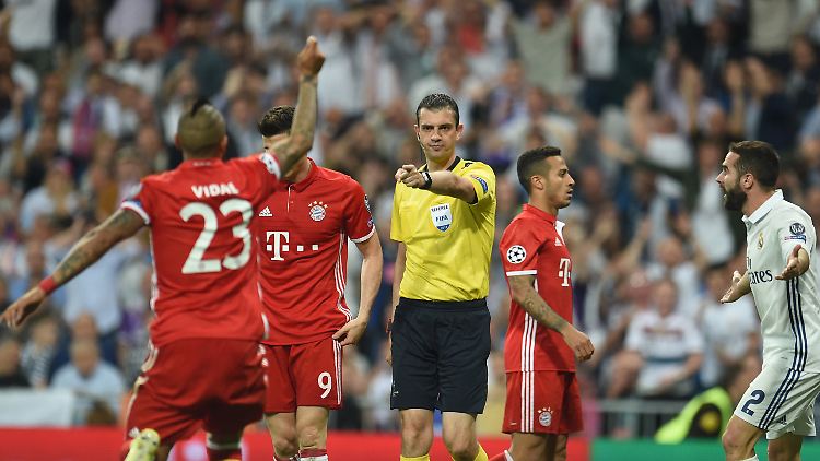 Schiedsrichter Viktor Kassai gestikuliert neben Arturo Vidal, Robert Lewandowski und Thiago Alcantara von Bayern München sowie Dani Carvajal von Real Madrid.