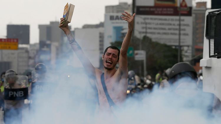 Ein Demonstrant in Caracas: Nackt richtete er seinen Appell an die Polizei, die ihn in Tränengas einhüllt.