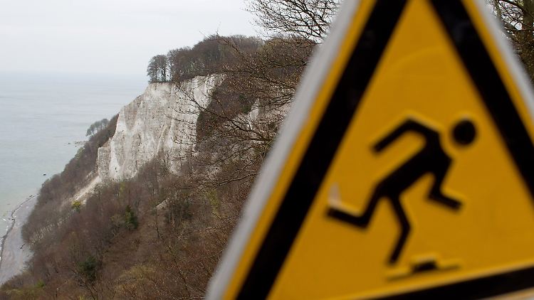 Schilder warnen Touristen an den Kreidefelsen vor der tödlichen Gefahr. 