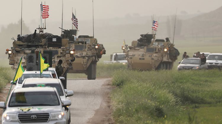 Autos der YPG führen einen Konvoi von US-Militärfahrzeugen an, die an der türkischen Grenze patrouillieren.