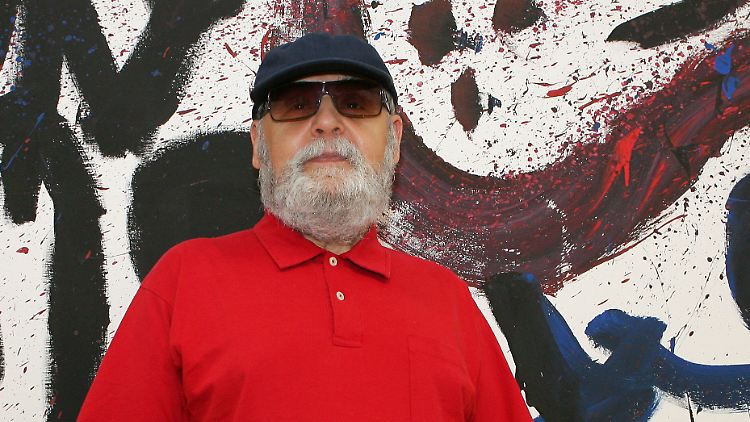 Der Künstler A.R. Penck vor einem seiner Bilder.