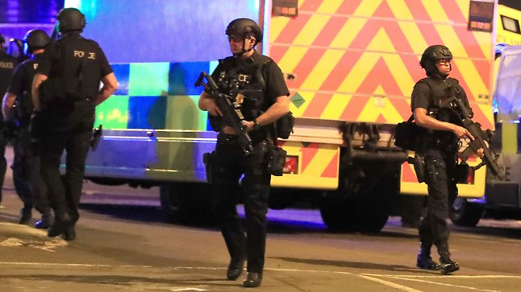 Schwerbewaffnete Polizisten sichern das Gebiet rund um die Halle.