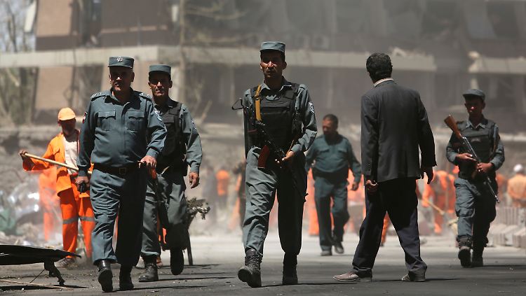 Sicherheitskräfte inspizieren den Ort des Anschlags in Kabul - im Hintergrund die deutsche Botschaft.
