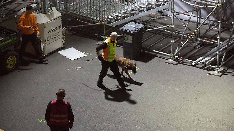 Ein Polizist geht mit einem Spürhund auf die Volcano Stage, die Hauptbühne des Festivals.