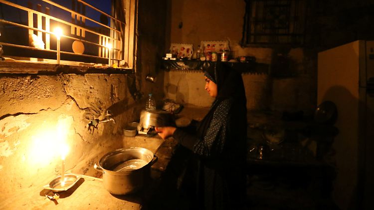 Ein Mädchen erledigt im Kerzenschein den Küchenabwasch in Gaza. Derzeit haben die Menschen dort täglich etwa vier Stunden Strom.
