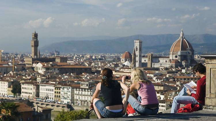 Junge Leute schauen von der Piazzale Michelangelo auf Florenz.