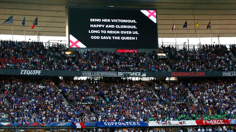 Texthilfe für die Franzosen: "God save the Queen" wird für sie auf der Stadionleinwand eingeblendet.
