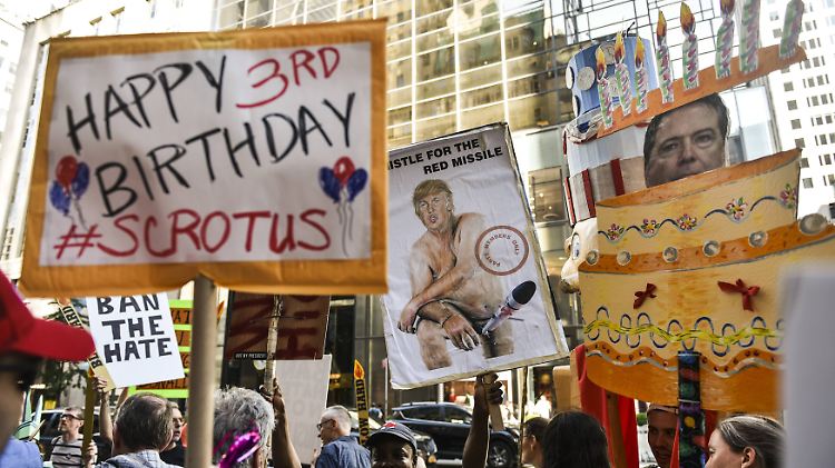 Ein paar New Yorker feiern am Mittwoch vor dem Trump Tower den 71. Geburtstag des Präsidenten auf ihre Weise.