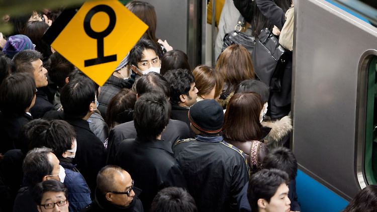 Pendler steigen in Tokio in eine U-Bahn.