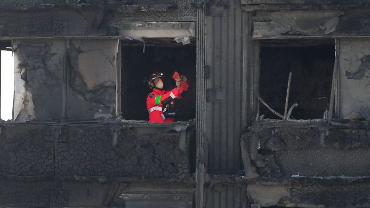 Ein Feuerwehrmann inspiziert eine Etage des ausgebrannten Hochhauses.