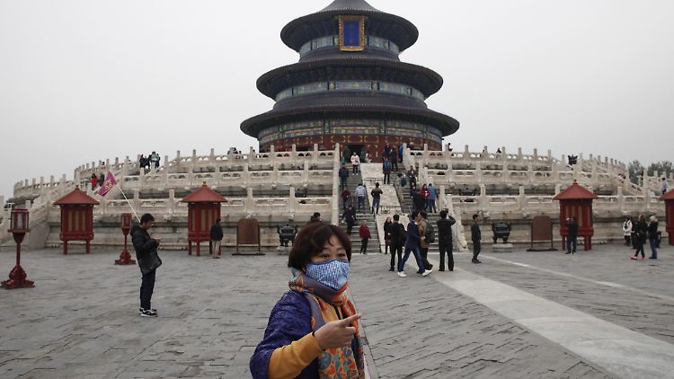 Touristin in Peking mit Mundschutz.