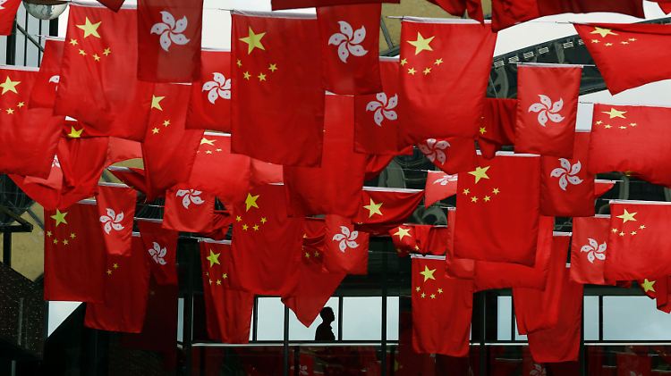 Chinesische Fahnen und die Flagge von Hongkong hängen in der Metropole am Südchinesischen Meer.